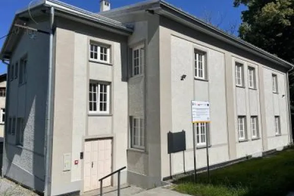 Zdjęcie przedstawiające dwukondygnacyjny budynek o jasnej elewacji.